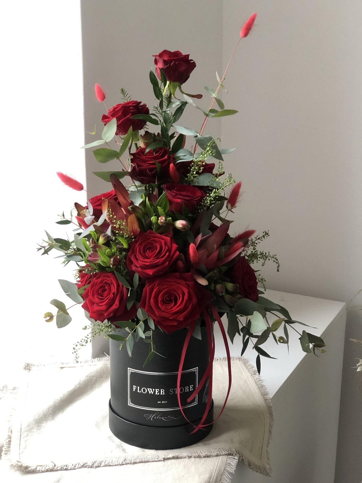 Kompozycja z czerwonymi różami - kwiaty żywe czarny box z grafiką - kwiaty Flower Store Warszawa